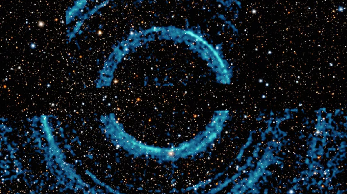 (1) Concentrische rimpelingen in galactische stofwolken veroorzaakt door een de uitbarsting van een zwart gat. Beeld: NASA/CXC/U.Wisc-Madison/S. Heinz et al.; Optical/IR: Pan-STARRS